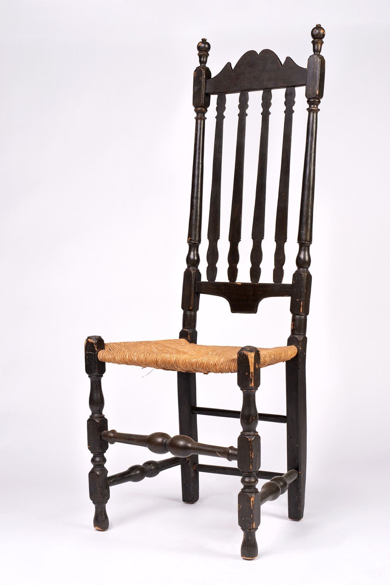 A rare William and Mary period banister backed sidechair with canted back, shaped crest, well-turned finials, posts and stretchers.